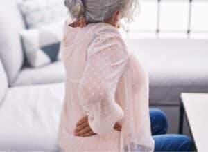 Woman sitting on couch with back pain